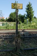 Dieses in Enzisweiler stehende Hinweisschild wurde vom kurz zuvor vorbeigekommenen Mähtrupp nicht vollständig vom Unkraut befreit (11.09.2016).