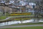Ein Zug der SSB spiegelt sich im Teich am Rosensteinpark.