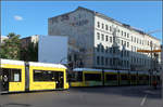 Im Licht und im Schatten -    Begegnung zweier Flexity-Straßenbahn in Berlin an der Kreuzung Friedrichstraße / Torstraße.