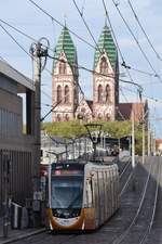 FREIBURG im Breisgau, 20.10.2019, Zug Nr. 307 als Tram1 nach Littenweiler in der Haltestelle Stadttheater mit der imposanten Herz-Jesu-Kirche im Hintergrund