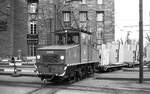 SSB Stuttgart__Arbeitsfahrzeuge der SSB in den 70er und 80er Jahren. A-Lok 2025 [ME/BBC 1946; Vk 1984 an Straßenb.Würzburg] mit 3 Flachwagen, beladen mit Trafos und Schaltschränken biegt beim Hbf. in die Königstraße ein.__08-01-1976