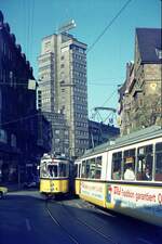 SSB Stuttgart__DoT4 930 als E-Wagen im Frühverkehr nach Bad Cannstatt, in Begegnung mit GT4 auf Linie 21, in der Eberhardstr., hinten der Tagblattturm (erstes Hochhaus Stuttgarts) von