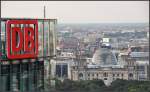 Die DB in Berlin -     Blick am DB-Keks der Bahnzentrale vorbei zum Reichstag, dahinter ein IC-Zug auf der Stadtbahn.