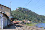 Der Bahnsteig 1 in Königstein (Sächs Schw) am 29.07.2024, mit Blick Richtung Dresden. Im Hintergrund zieht die DB 146 213-4 die S 31729 (S1) von Meißen Triebischtal nach Schöna.