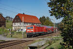 143 012 zog am 09.10.2024 ihre S1 nach Schöna am Fachwerkhaus in Rathen vorbei.