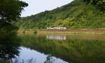 Auf der Fahrt von Düsseldorf nach Luxemburg spiegelt sich der IC/RE 1 5106 am 25.07.2024 bei St. Aldegund in der Mosel