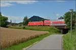 Sommertag im Hegau. Hier kommt eine 146 mit IRE der Schwarzwaldbahn in die Bodenseeregion. Im Hintergrund der hchste Hegauvulkan Hohenhewen, der Kirchturm linkerhand markiert den mittelalterlichen Ortskern von Engen. Juli 2012.