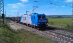 185 517 der HLG ist am 17.05.2012 mit einem Holzzug auf der KBS 820 bei Neuses an der Regnitz unterwegs.