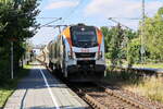 Havelländische Eisenbahn AG aus Berlin-Spandau mit 159 002 (NVR-Nummer: 90 80 2159 002-5 D-HVLE) und einem Schüttgutförderzug bei der Durchfahrt durch den Bahnhof Dabendorf am 25. Juni 2024. 