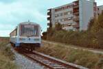 Der Zug der Strohgäubahn Korntal-Weissach und das Hochhaus daneben entsprechen sich in etwa in ihrer Farbgebung.