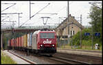 OHE 185534 fährt hier am 13.8.2005 mit einem Container Zug in Richtung Norden durch den Bahnhof Linsburg. Im Hintergrund rechts ist das alte Bahnhofsgebäude zu sehen.