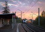 Ein Alstom Coradia Continental-Triebzug der Mitteldeutschen Regiobahn durchfährt am Abend des 01. Mai 2019 den Haltepunkt Chemnitz-Hilbersdorf als RE 3 nach Dresden Hbf. Im Hintergrund ist der Schornstein des Heizkraftwerks Chemnitz-Nord zu sehen.