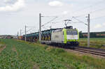 185 517 schleppte am 11.06.22 einen Containerzug, bei dem im vorderen Teil Flachwagen mit Traktoren von John Deere eingereiht waren, durch Rodleben Richtung Roßlau.