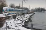 Gezeichnet von der Fahrt durch den Allguer Schnee erreicht ein ALEX in Krze Lindau Hbf.