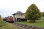 212 047 + 212 370 am 12.10.2008 vor dem Bahnhofsgebude von Gebenbach mit einem Schotterzug.