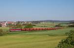 232 088 am 19.05.2011 mit einem langen Schotterzug vor der Kulisse des Ortes Gebenbach.