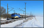 Bei schönstem Winterwetter zieht 140 798-0 der EVB einen Autozug mit passend zur Umgebung verkleideten Fahrzeugen durch die Börde bei Wellen.