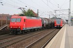 Während des Halts der S-Bahn am Bahnsteig rauscht 145-CL 015 (145 093-1) der HGK mit einem Kesselwagen in Fahrtrichtung Osten durch Hannover Linden-Fischerhof.