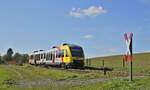 Laut pfeifend nähert sich der HLB-VT 255 auf der Fahrt von Siegen nach Bad Berleburg am 11.10.2022 einen Feldwegübergang bei Lützel