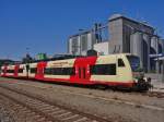 Vor den im Hintergrund stehenden Getreidesilos der BayWa fahren am 02.08.2013 VT 212 und VT 200 der Hohenzollerischen Landesbahn im Bahnhof von Biberach (Ri) ab.