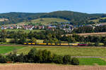 Epoche IV Feeling im osthessischen Haunetal. Die purpurrote 218 155 der NeSA beförderte am 21. September 2024 eine Schienenschleifmaschine der Schweerbau bei Hermannspiegel in Richtung Fulda. Im Hintergrund befindet sich die Ortschaft Hauneck.