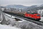 Schnee am Bözberg und dazu eine für den entsprechenden Farbtupfer passende Lok: 185 587-3 der RheinCargo ist mit Staubsilowagen nach Siggenthal (via Wettingen) unterwegs, aufgenommen am