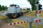 Die DH 706 der Rhein Cargo passiert am 18.06.2015 auf dem Weg zum Hafen Stürzelberg  den Bahnübergang der Industriebahn Zons-Nievenheim in Höhe von km 2,880