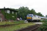 Links die zugewachsene Blockstelle und rechts die MAK DE 2700-02 der Nord-Ostsee-Bahn (NOB) mit NOB 80516 Hamburg Altona-Westerland (Sylt) in Friedrichstadt am 21-6-2007.