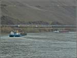 Bei regem Schiffsverkehr und migem Wetter fhrt eine Trans Regio Doppeleinheit ET 460 auf der linken Rheinstrecke in der Nhe von Boppard an den noch kahlen Weinbergen vorbei.