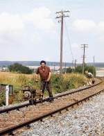 Anziehen der Hakenschrauben des Durchgangsgleises nach dem Ausbau der nrdlichen Bahnhofsweiche in Neu Anspach am 13.8.1984 - die beginnende Rckstufung zum Haltepunkt, 1. Hlfte der 1980iger Jahre.
