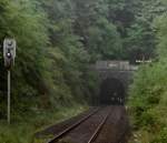 (1/3) Schienenbus Richtung Wetzlar vor der Ausfahrt aus dem Hasselborner Tunnel - der weie Fleck rechts vom Spitzsignal des Schienenbusses ist das Sdportal des gradlinig verlaufenden Tunnels, 1.