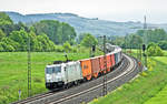 Voll aus dem Gegenlicht kommt morgens des 2.5.2018 die TX Logistik 185 418-3 mit einem Containerzug in Gambach vorüber.