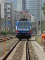 Zoom sei Dank: Die Werbelok 185 513-9 von TXLogistik in Warteposition auf dem Wiener Donauuferbahnhof; dahinter der 202m hohe Millenniumsturm (6.6.2009).