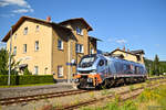 Die Eurodual 2159 248 im Einsatz für die Netzwerkbahn Sachsen wartet am 25. Juni 2024 nach einigen Rangierarbeiten vor dem ehem. Bahnhofsgebäude Pockau-Lengefeld auf die fertige Beladung der noch leeren Holzwagen um diese später noch nach Freiberg zu bringen.