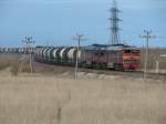 2T3116-1681 schlngelt sich die Rampe von der Staatsstrassenberfhrung hinunter, Leerwagenzug Richtung Osten, Maardu. Diese Zge wirken besonders durch die 63, meist uniformen Waggons - 15/04/2008