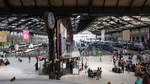 (Querschnitts-)Blick über die Halle 1 des  Gare de Lyon  zu Paris.

Im Vordergrund eine historische Bahnhofsuhr, im Hintergrund stehen ein paar angekommene oder bald abfahrende TGV- und Vorort-Züge.

Paris, der 19.8.2019