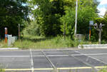 Fahren hier noch Züge: Ziemlich zugewachsenes Trassee bei einem Bahnübergang bei Les Croisées. Die Signalisation ist hier vollständig erhalten. Auf Grund der Tatsache, dass ich das Senken der Schlagbäume mit Sicherheit bemerkt hätte, wagte ich mich für dieses Foto ins Lichtraumprofil. Les Croisées, 4.6.2024