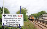 Triebzug 156 448 verlässt den Bahnhof Ravenglass im Nordwesten Englands. Eine grosse Tafel zeigt an, wo es zur kleinen Ravenglass & Eskdale Bahn geht. 13.Juni 2024 