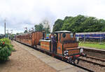 Bluebell Railway, eine alte Zugskomposition mit Lok 72 (Britisch Railways 32636 von 1872) fährt in Horsted Keynes ein. Sie zieht drei historische Wagen: 387 und 394 der Metropolitan Railway. Wagen 387 stammt von 1898 und hat 5 Abteile und einen Gepäckraum, 394 stammt von 1900 und hat 7 Abteile. Die Metropolitan Railway ist die älteste U-Bahn der Welt für Personentransport und existierte 1863-1933, bevor sie in den Londoner Verkehrsbetrieben aufging. Die Wagen standen bis 1961 dort im Einsatz. 1940 wurden sie für den Dampfbetrieb auf aussenliegenden Strecken hergerichtet, wobei 394 zum Steuerwagen wurde. Beide Metropolitan Wagen kamen schon 1961 zur Bluebell Railway. Ein interessantes Detail ist die im Metropolitan Wagen 387 angebrachte Tafel mit Instruktionen, wie man sich im Falle eines Luftangriffs zu verhalten hat. Zuhinterst läuft der Aussichtswagen 1503 der einstigen London & North-Western Railway, der 1913 für die Bergstrecke Llandudno-Blaenau Ffestiniog in Nord-Wales gebaut wurde und dort bis 1958 im Einsatz blieb. Er gelangte 1963 zur Bluebell Railway. Aufnahme 16.Juni 2024 

