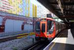 Die neue  S-Klasse  der London Underground in der Station  Edgeware Road  - vor der Kulisse des  Wrapper , dem angeblich größten Emaille-Kunstwerk der Welt.