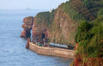 Ein Lokalzug von Paignton nach Exmouth fährt zwischen Teignmouth und Dawlish durch eine imposante Landschaft mehr oder weniger direkt dem Meer entlang.