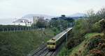 Der DART-Vorortbahnzug 8111 von Bray nach Howth ist im April 1992 bei Killiney unterwegs, links im Hintergrund der Bray Head, den die Fährpassagiere aus Holyhead/Wales schon lange vor der Ankunft