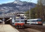 Im März 1985 fährt E 633 065 mit einem Güterzug durch Trento, daneben wartet ALn 668 1214 auf Fahrgäste für die Valsuganabahn
