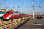 
Ausfahrt eines sehr langen  Frecciarossa  (deutsch: roter Pfeil) der Trenitalia (100-prozentige Tochtergesellschaft der Ferrovie dello Stato (FS)) am 29.12.2015 vom Bahnhof Milano Centrale (Mailand Zentral). 

Der Frecciarossa ist eine Zuggattung für Züge mit einer Höchstgeschwindigkeit von 300 km/h. Hier ist es der ETR 500 - 56 ein ETR 500 der 2.Serie. ETR steht ElettroTreno Rapido. 