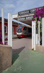 Die blühende Bougainvillea und der abfahrbereite Zug laden ein, eine Fahrt mit der Ferrovia Circumetnea zu unternehmen. Leider ist dies der letzte Zug, der Catania Borgo in Richtung Paternò verlässt und damit nur durch Catanias Vorstädte fährt. 
