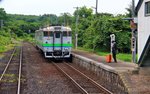 Lokalverkehr auf Hokkaidô: Mann mit orangem Koffer wartet im Nirgendwo auf einen Zug, der kaum je kommt.