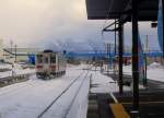 Lokalverkehr in Ost-Hokkaido: KIHA 54 507 fährt aus der Station Shiretoko Shari aus; im Hintergrund die Vulkankette der Shiretoko Halbinsel.