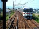 Serie 313: Ein Sechswagenzug mit ostseitigem motorisiertem Endwagen KUMOHA 313-5008 in Nishi Kozakai bei der Stadt Toyohashi, Tôkaidô-Stammlinie.