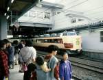 Serie 481 / 485: Ein doppelt historisches Bild - seit Jahrzehnten waren die carminrot/beige-gestrichenen Intercity-Züge Serie 481/485 das Rückgrat der Küstenlinie nach Akita, und seit Jahrhunderten trugen japanische Frauen ihre Kinder auf dem Rücken. Beides gibt es so nicht mehr. Frontwagen mit Luxussitzen KURO 481-1009 in Akita, 19.April 1997. 