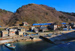 Die Nordwestküste Japans, Hauptlinie Niigata - Akita am Japanischen Meer: Ein Expresszug Serie 653 von Niigata nach Akita im Fischerdörfchen Wakigawa.